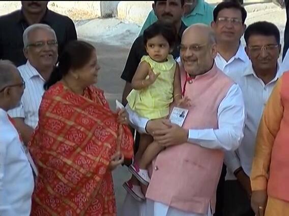 Amit Shah with his grand-daughter, waves at people